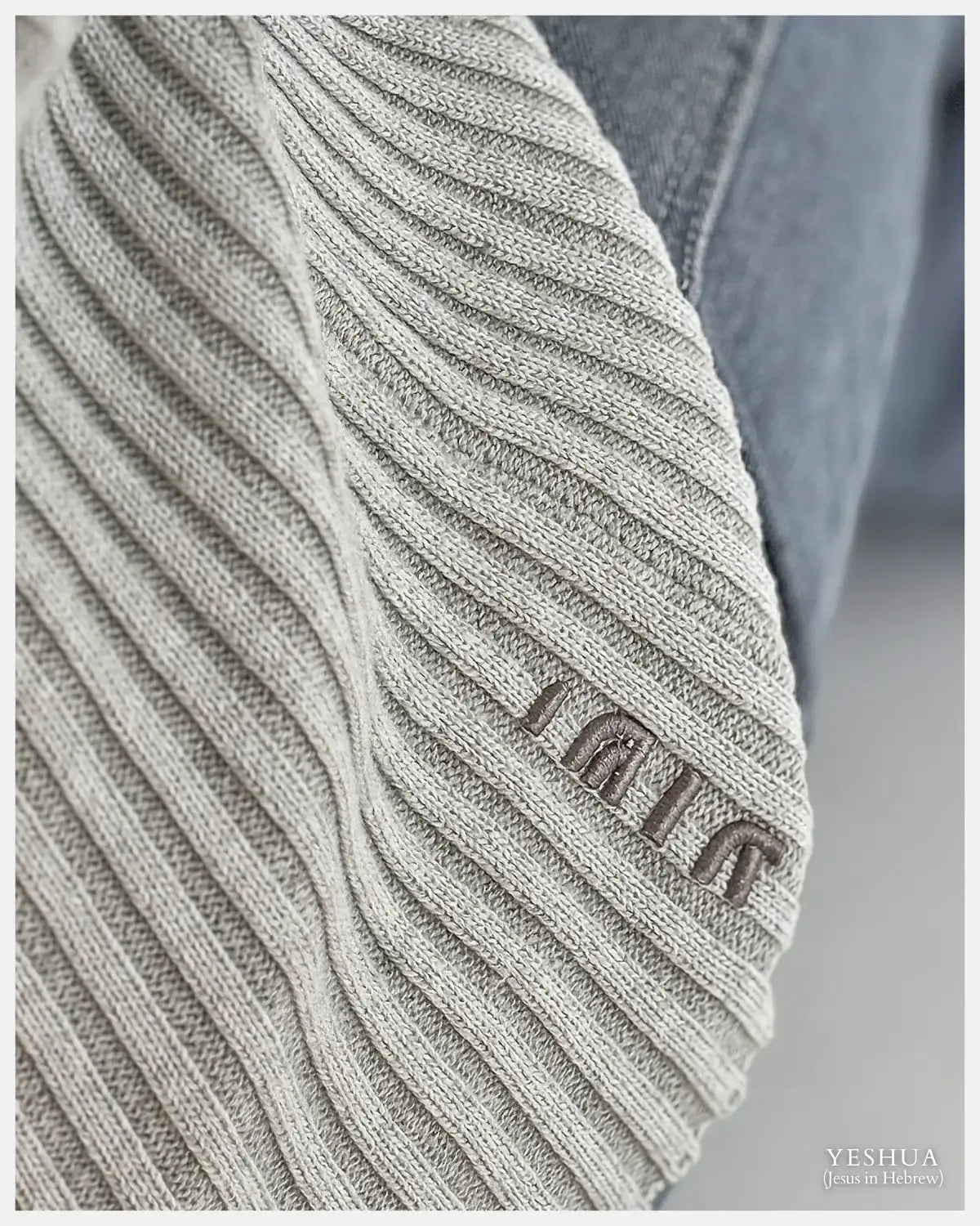 Close-up of ribbed knit beige beanie with Yeshua embroidered in Hebrew, Christian luxury apparel